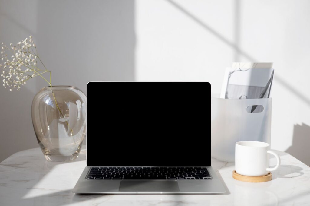 Desk with a laptop and coffee, illustrating whether Claude Cowork is free and how the free week guest pass works