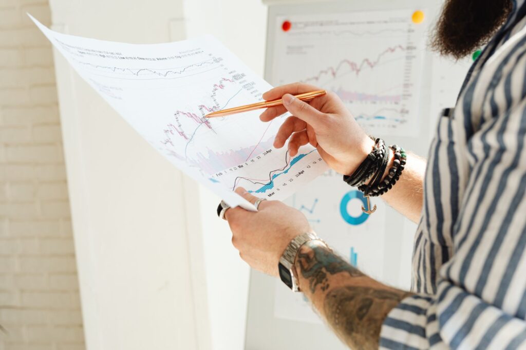 Analyst checking investment charts and a paper report, illustrating a WeTradeX review of its advertised returns
