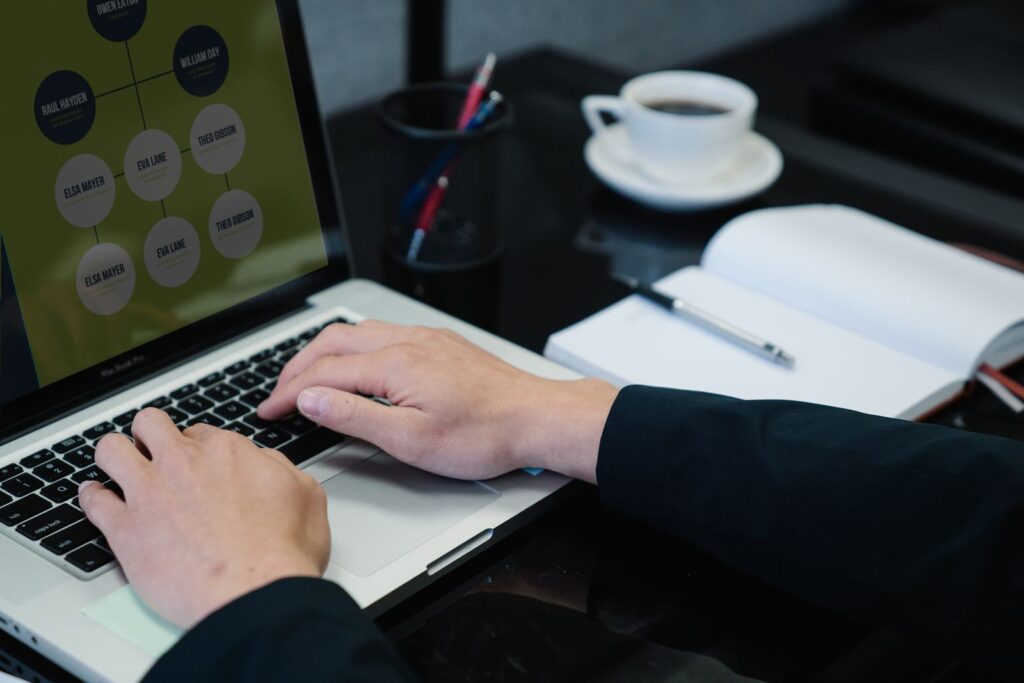 Hands typing on a laptop showing a workflow diagram, illustrating how AI automation connects business processes